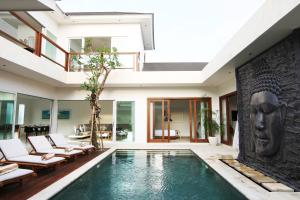 - une piscine dans une maison avec une face sur le mur dans l'établissement Villa Aditi, à Seminyak