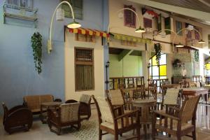 a restaurant with tables and chairs in a room at Omah Njonja Bed & Brasserie in Yogyakarta