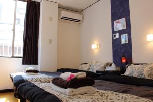 1 dormitorio con 2 camas y toallas. en Holiday Homes TSUBOYA 1st en Naha