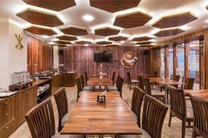 a dining room with wooden tables and chairs at Hotel City Inn in Gandhinagar