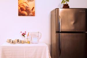 una cucina con frigorifero accanto a un tavolo con sidro di seta di D'Villa Guest House a Jaffna
