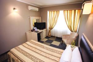 a hotel room with a bed and a television at Aktau Hotel in Aktau