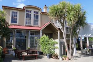 een huis met palmbomen ervoor bij La Riviera Guesthouse in Riverton