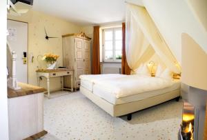 um quarto com uma cama de dossel e uma secretária em Hotel Restaurant Lohmühle em Bayreuth