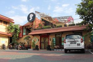 a white car parked in front of a building at Omah Njonja Bed & Brasserie in Yogyakarta