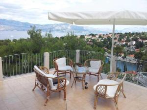 patio con tavolo, sedie e ombrellone di Villa Ujoli a Splitska