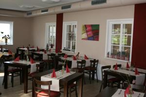 a dining room with tables with red napkins on them at Gasthaus-Pension Schwarzer Graf in Windischgarsten