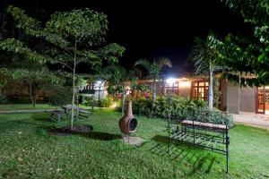 a yard at night with two benches and a vase at Arusha Planet Lodge in Arusha