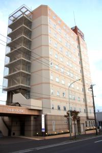 een groot gebouw op de hoek van een straat bij Hotel Route-Inn Sapporo Shiroishi in Sapporo