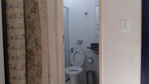 a small bathroom with a toilet and a shower at Joao Meira Apartments in Guarapari