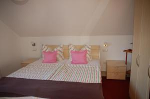 a bedroom with a bed with pink and white pillows at Erholungsfuechse Andechs in Andechs