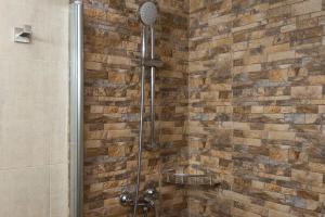 a shower in a bathroom with a brick wall at H. Ciudad de Lepe in Lepe