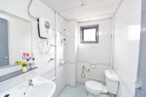 a white bathroom with a toilet and a sink at Kijal Family Apartment in Kijal +24 photos