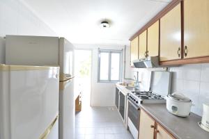 a kitchen with a refrigerator and a stove at Kijal Family Apartment in Kijal