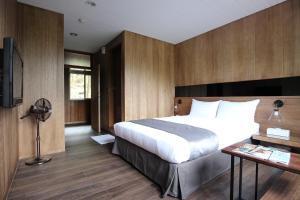 a bedroom with a bed and a desk and a television at Taichung Business Hotel - Immortals Hills in Heping