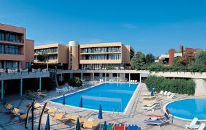 a hotel with a pool and chairs and a building at Hotel Holiday in Sirmione