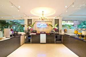 a restaurant with a buffet line with a chandelier at LK Mantra Pura Resort in Pattaya