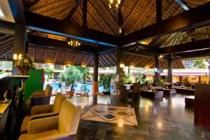 a lobby of a resort with couches and tables at LK Mantra Pura Resort in Pattaya