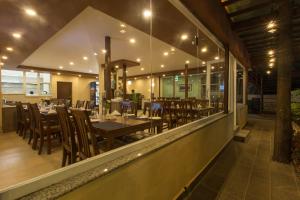 un restaurante con mesas de madera, sillas y luces en Oasis Kathmandu Hotel en Katmandú