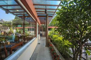 an outdoor patio with a table and benches and trees at Oasis Kathmandu Hotel in Kathmandu