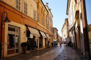 una calle adoquinada en un casco antiguo con edificios en Il Cielo in Una Stanza, en Rávena