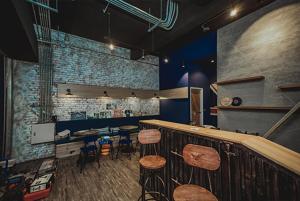 a restaurant with stools and a bar in a room at Urban in Kaohsiung