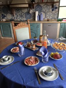 Farini dʼOlmo的住宿－Orto dei Semplici，一张桌子,上面有盘子,放在蓝色的桌布上