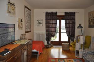 Schlafzimmer mit einem Bett, einem TV und einem Fenster in der Unterkunft Appartamento Nino in Aosta