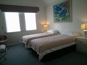 a hotel room with two beds and a window at Beachside Apartment in Albany