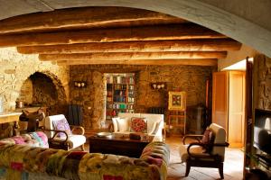 een woonkamer met meubels en een stenen muur bij La Casa di Ester nel Cilento in Angellara