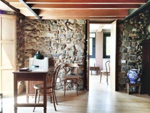 een eetkamer met een stenen muur en een tafel en stoelen bij La Casa di Ester nel Cilento in Angellara