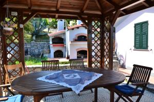 a wooden table and chairs on a patio with a fireplace at Villa Il Pettirosso in La Spezia