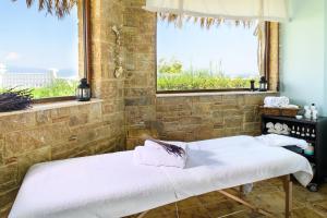 two beds in a room with two windows at Antigoni Seaside Resort in Ormos Panagias