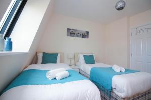 two beds in a room with white and blue at Castle Point Apartments Southampton Premier Lodge in Southampton