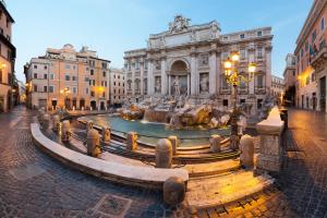 a fountain in a street in front of a building at La Casa di Nonna Rosa in Rome