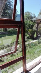 an open window with a view of a yard at Guest Lodge on the Edge in Stormsrivier