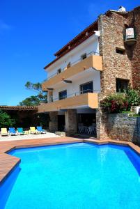 a villa with a swimming pool in front of a building at Hotel Sa Riera in Begur