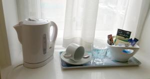 a kitchen counter with a coffee maker and a cup at The Ratcliffe Guest House in Paignton