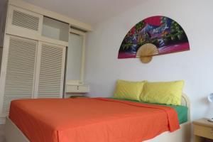 a bedroom with a bed with an orange blanket at View Talay 1B Residence in Pattaya South