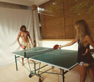 dos personas jugando ping pong en una mesa de ping pong en Surfing Wombats, en Weligama