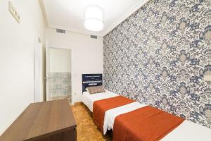 マドリードにあるEl Jardín del Ángel Lavapiesのベッドルーム1室(ベッド2台付)が備わります。壁紙を用いた内装です。