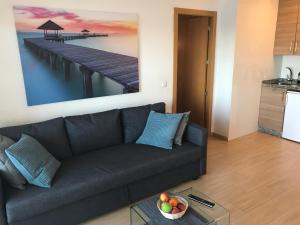 a living room with a couch and a painting of a pier at Apartment Stella Maris in Fuengirola