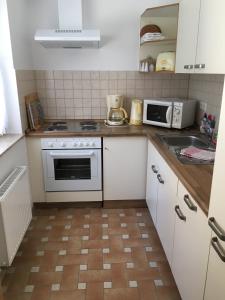 a kitchen with white cabinets and a white stove top oven at Ferienhaus Daul in Wandlitz