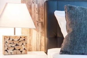 a lamp on a table next to a pile of fire wood at Hotel Stay in Essen