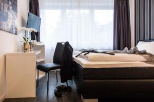 ein Schlafzimmer mit einem Bett und einem Stuhl neben einem Fenster in der Unterkunft Hotel Stay in Essen