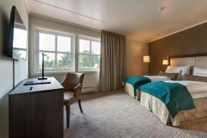 a hotel room with two beds and a desk at Clarion Hotel Oslo Airport in Gardermoen +62 photos