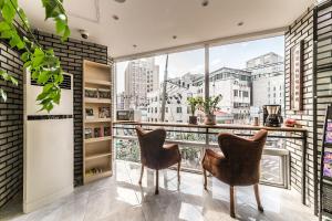 a room with two chairs and a balcony with a view at MyeongDong New Stay Inn in Seoul