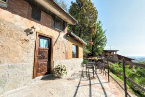 a stone house with a wooden door and a patio at Ippotur Medieval Resort in Castelnuovo Magra