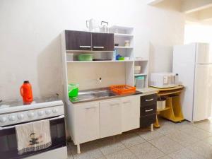 a kitchen with a sink and a refrigerator at Casa Para Locação in Piratuba