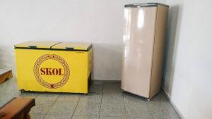 a yellow box sitting on the floor next to a refrigerator at Casa Para Locação in Piratuba